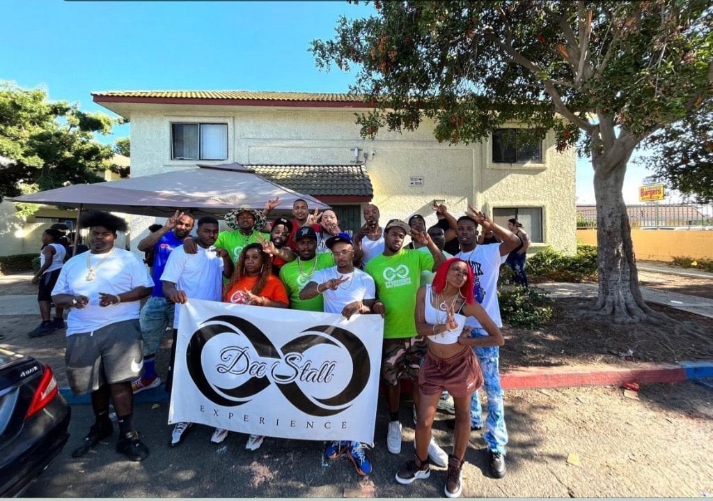 Large group of Dee Stall Experience team members and volunteers holding the DSE banner