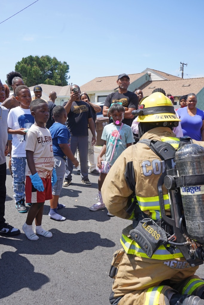 Firefighter in full gear engaging with children up close at a DSE event