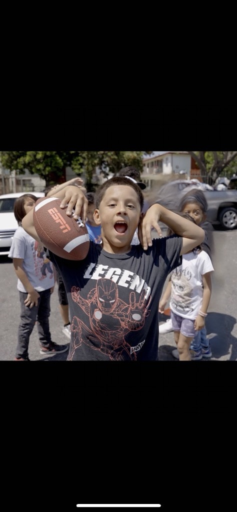 Youth showing off a football at a DSE community event