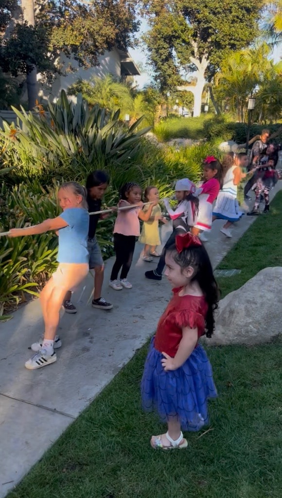 Children playing tug of war in a garden at a DSE community event